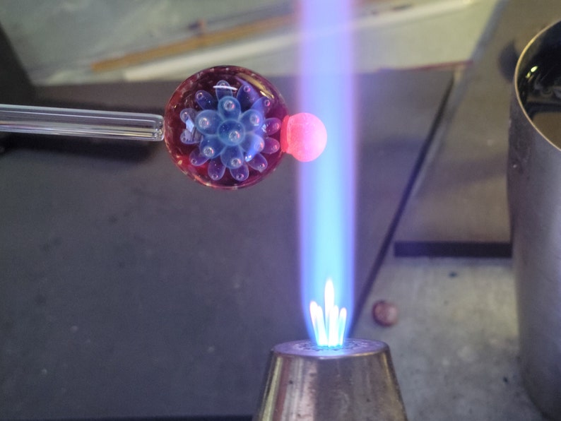 Image of a  pendant being shaped in the flame of a blowtorch.