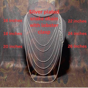 Display bust showing multiple silver-plated snake chains layered by length, labeled from 16 to 26 inches, each with a lobster clasp, demonstrating available necklace length options on a dark textured background.