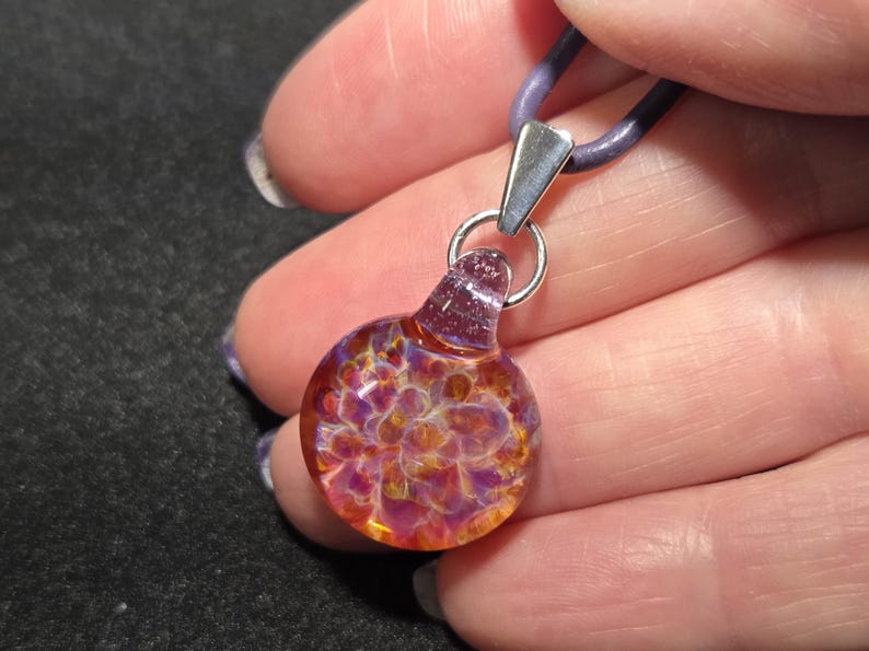 Handcrafted art glass necklace featuring a tiny autumn choker pendant with vibrant trippy colors, reflecting light to highlight its unique depth and detail.
