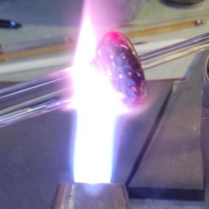 Image of a  pendant being shaped in the flame of a blowtorch.