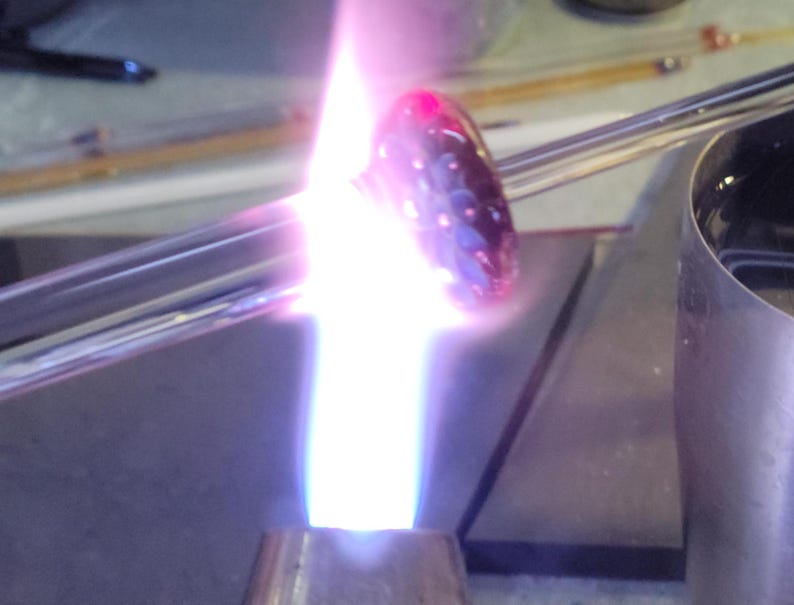 Image of a  pendant being shaped in the flame of a blowtorch.