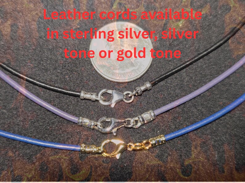 Close-up of leather necklace cords shown with 10mm large lobster claw clasps, displayed in sterling silver, silver tone, and gold tone finishes, with a U.S. quarter above for size reference on a dark textured background.