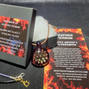 Image of the pendant and a jewelry box labeled with the business name. A business bookmark explains the glassmaking process, accompanying the pendant for a complete gift presentation.