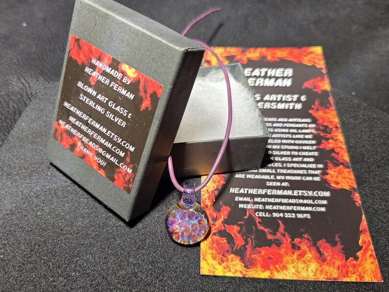 Image of the pendant and a jewelry box labeled with the business name. A business bookmark explains the glassmaking process, accompanying the pendant for a complete gift presentation.