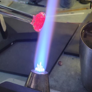 Image of a  pendant being shaped in the flame of a blowtorch.
