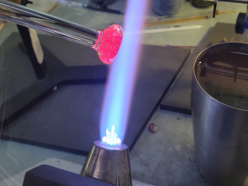 Image of a  pendant being shaped in the flame of a blowtorch.