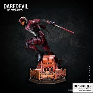 Könnte beinhalten: Eine Statue von Daredevil in dynamischer Pose, bekleidet mit einem rot-schwarzen Anzug, der einen Stab hält. Die Statue steht auf einem verzierten, detaillierten Sockel mit dem Text "DAREDEVIL VS PUNISHER" oben. Der Hintergrund ist dunkel.