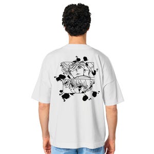 Op de afbeelding: Wit T-shirt met een zwart-witte grafische print van twee anime-personages. De grafiek bevat zwarte inktvlekken.