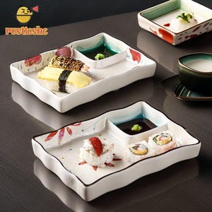 May include: White ceramic sushi plates with a wavy edge, featuring a compartment for soy sauce and wasabi. The plates are decorated with red and pink floral accents and hold various sushi rolls and nigiri.