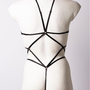 Puede incluir: Lingerie negra con un diseño de correas cruzadas en la espalda.