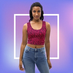 Könnte beinhalten: Ein pinkfarbenes und schwarzes Crop-Top mit Zebra-Muster. Das Top ist ärmellos und hat einen runden Ausschnitt.
