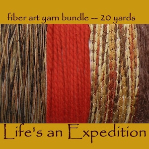 May include: A fiber art yarn bundle measuring 20 yards, featuring four distinct textures and colors: a brown and gold variegated strand, a solid red twisted yarn, a metallic gold and brown ribbon-like strand, and a fuzzy dark brown yarn. Text reads: fiber art yarn bundle -- 20 yards and Life's an Expedition.