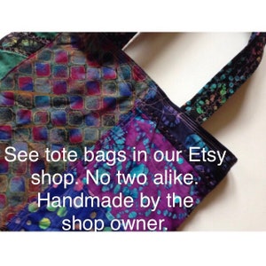 Puede incluir: Primer plano de una bolsa de mano de patchwork colorida con una correa negra. La bolsa est&aacute; hecha de diferentes telas y tiene un dise&ntilde;o &uacute;nico. El texto "See tote bags in our Etsy shop. No two alike. Handmade by the shop owner." es visible en la bolsa.