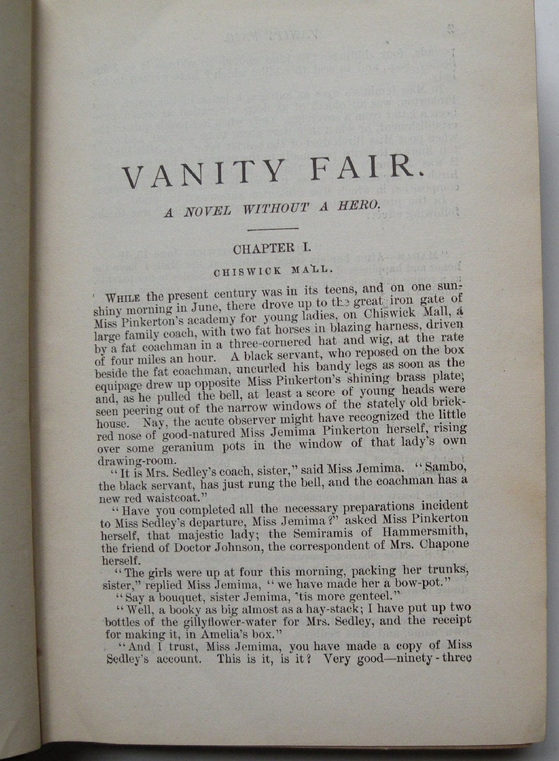 May include: A page from a vintage book titled "Vanity Fair: A Novel Without a Hero." The text describes a carriage arriving at a school for young ladies. The text includes the names Miss Pinkerton and Miss Jemima.