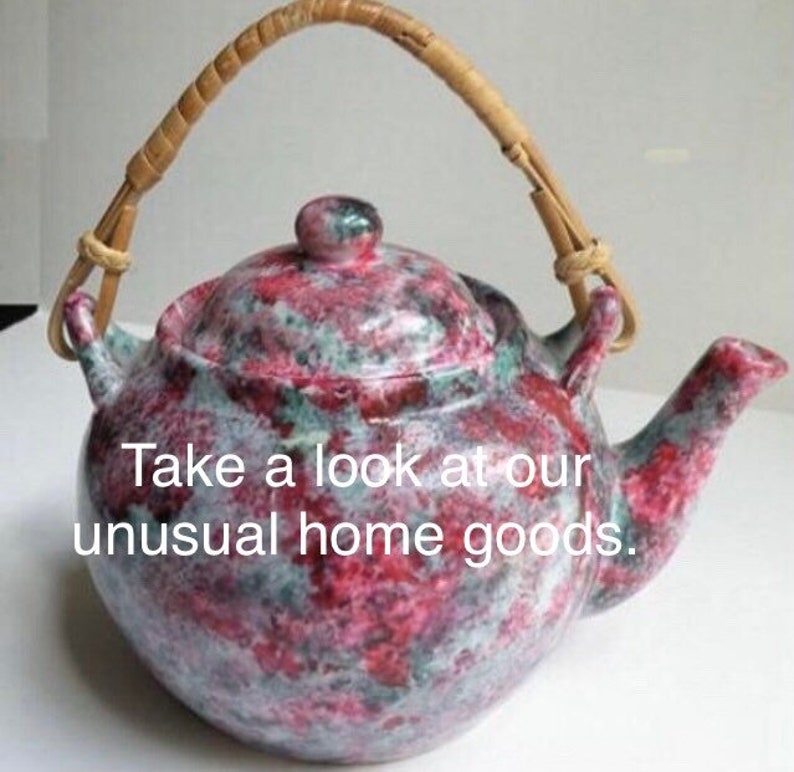 May include: A red and white speckled teapot with a brown woven handle. The teapot has a lid and a spout.