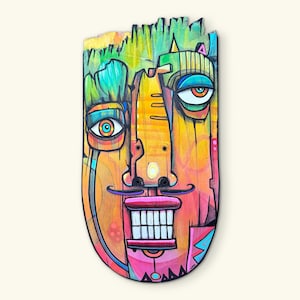May include: A colorful, abstract wooden mask with a face design. The mask features a wide grin with white teeth, a mustache, and large eyes. The color palette includes orange, yellow, pink, blue, and green.