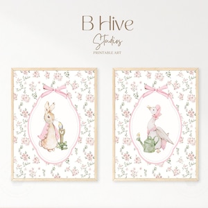May include: Two framed prints with a floral background. The print on the left features a rabbit holding a candle and the print on the right features a duck holding a watering can.