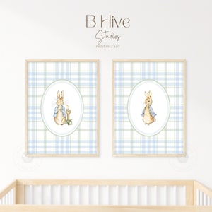 May include: Two framed prints of Peter Rabbit in a blue and green plaid pattern. The prints feature Peter Rabbit in a blue jacket and brown pants, standing in a green oval.