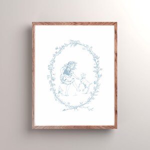 May include: A blue and white illustration of a girl and a dog in a wreath of flowers. The girl is wearing a dress and the dog is sitting on its hind legs. The illustration is framed in a light wood frame.