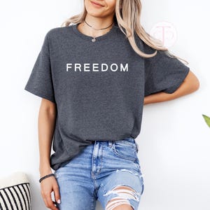 American pride shirt in red with FREEDOM lettering, unisex patriotic graphic t-shirt.

Political rally shirt with bold FREEDOM text, free speech and liberty graphic tee.