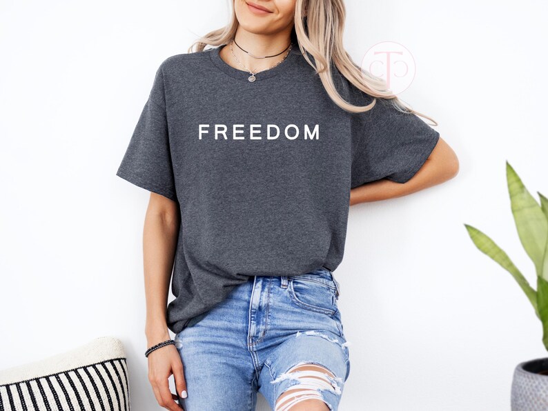 American pride shirt in red with FREEDOM lettering, unisex patriotic graphic t-shirt.

Political rally shirt with bold FREEDOM text, free speech and liberty graphic tee.