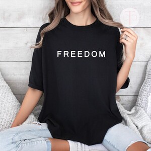 We the People patriotic shirt with bold FREEDOM graphic, unisex activist t-shirt.

Free speech graphic tee featuring simple bold FREEDOM design, Gildan unisex shirt.