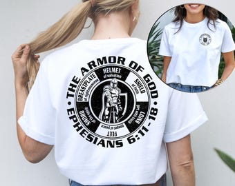 May include: White t-shirt with a black circular graphic on the back. The graphic features a knight in armor and the text "The Armor of God - Ephesians 6:11-18".