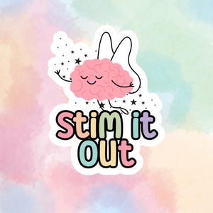 Puede incluir: Una pegatina troquelada que muestra un cerebro rosa de dibujos animados con alas de hada y una cara sonriente, rodeado de pequeñas estrellas negras. Debajo del cerebro, el texto "STIM it Out" aparece en letras redondeadas y coloridas.