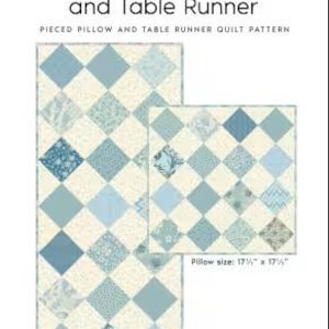 May include: A pieced quilt pattern titled Laundry Basket Quilts Gratitude Pillow and Table Runner. The design features blue and cream diamond-shaped fabric blocks. The pillow measures 17.5 inches by 17.5 inches and the table runner is 30.5 inches by 13.5 inches.