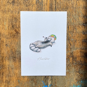 Könnte beinhalten: Eine Cartoon-Illustration eines Waschbären, der einen grün-gelb-roten Hut trägt und eine Zigarette in der Pfote hält. Der Text "Haschbär" steht unter dem Waschbären.
