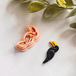 May include: A set of three ceramic mugs with a speckled, matte finish in cream, light grey, and dark grey. Each mug has a simple, minimalist design and a rounded handle.