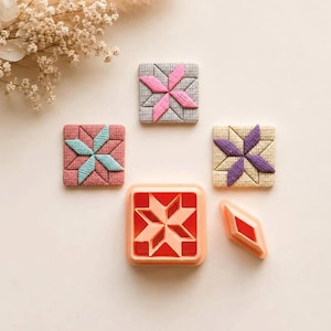 May include: Three square textured tiles featuring a star pattern in pink, light blue, and purple, alongside a square orange plastic cookie cutter with a star insert and a single diamond-shaped orange plastic cutter piece for crafting.