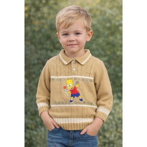 Könnte beinhalten: Senfgelber Zopfstrickpullover mit weißem Kragen und Bündchen. Der Pullover zeigt eine Cartoon-Grafik von Bart Simpson mit einem Skateboard. Der Pullover hat einen Knopfkragen und wird mit einer blauen Jeans getragen.