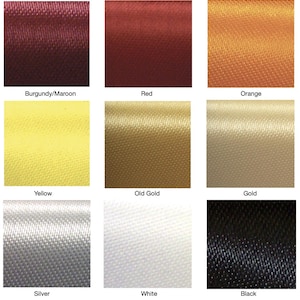 May include: Nine fabric swatches in various colors, including burgundy, red, orange, yellow, old gold, gold, silver, white, and black. Each swatch has a textured, satin-like appearance.