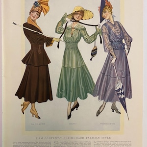 May include: An illustration from The Delineator for April 1916, featuring three women in elegant dresses. The dresses are in shades of brown, green, and purple, with matching hats and accessories. The text "I AM CONTENT." is visible.
