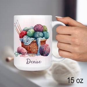 Könnte beinhalten: Weiße Keramiktasse mit dem personalisierten Namen "Denise" und einer bunten Illustration eines Korbs voller Wollknäuel und Stricknadeln. Die Tasse hat ein Fassungsvermögen von 15 Unzen.