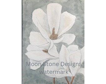 Könnte beinhalten: Aquarellmalerei von drei weißen Magnolienblüten mit braunen Zentren auf hellblauem Hintergrund. Das Gemälde ist signiert mit "Moon Stone Designs Wasserzeichen".