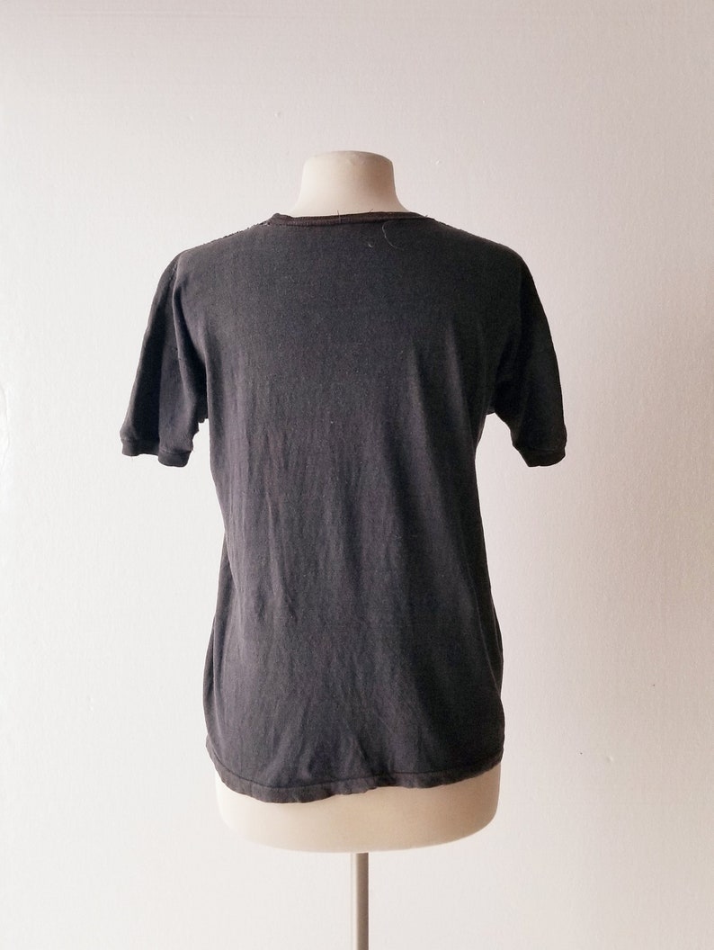 K&ouml;nnte beinhalten: Ein dunkelgraues T-Shirt mit kurzen &Auml;rmeln auf einer Puppe.