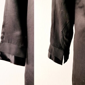 May include: A black long-sleeved shirt with a double-layered cuff detail. The shirt is made of a smooth, silky fabric.
