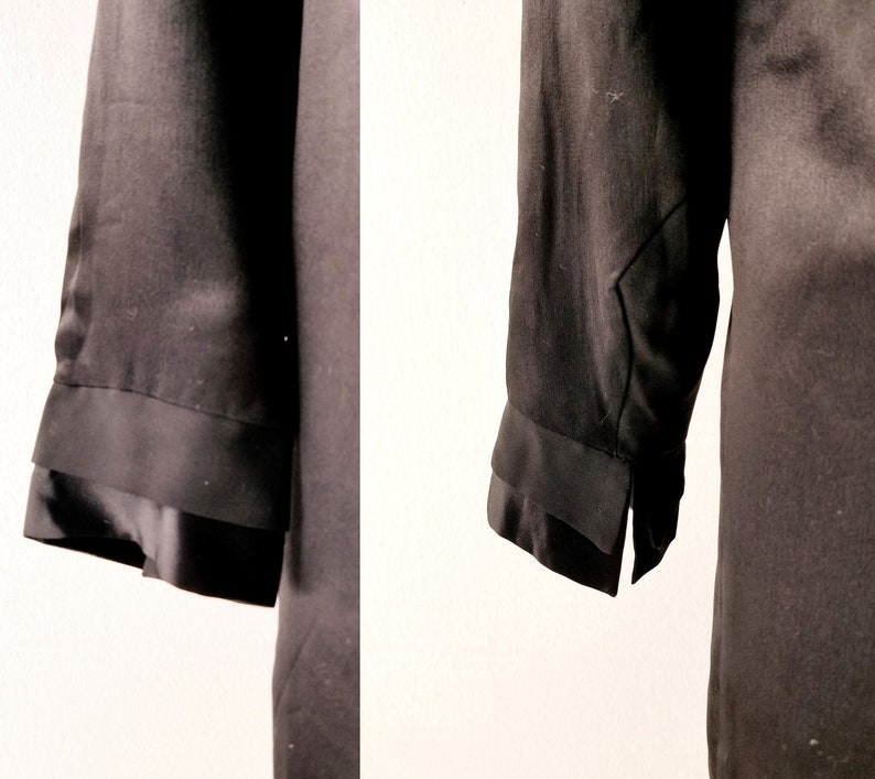May include: A black long-sleeved shirt with a double-layered cuff detail. The shirt is made of a smooth, silky fabric.