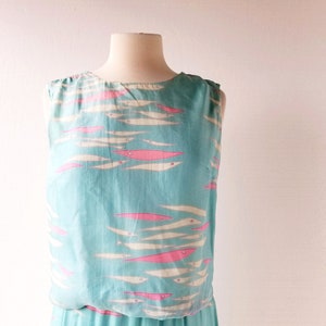 May include: A sleeveless maxi dress with a blue background and a pattern of pink and white fish.
