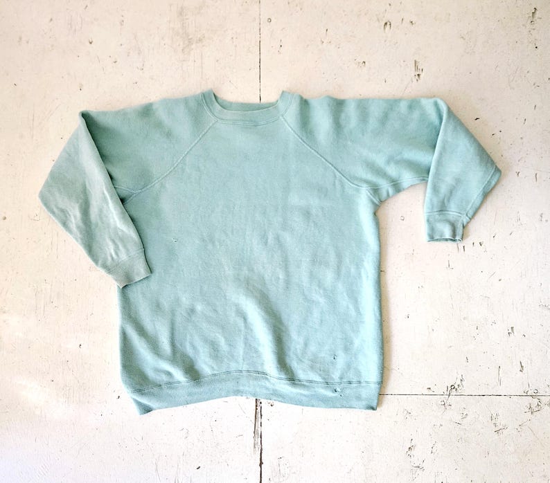 A vintage light mint green, crew neck, long sleeve pullover sweatshirt.