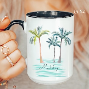 May include: White ceramic mug with a black rim and handle, featuring a watercolor design of three palm trees. The mug has the name "Molly" in script and is labeled "15 oz".