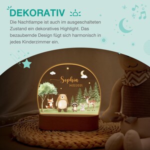 May include: A decorative night light with a wooden base and a curved, illuminated panel. The panel features a forest scene with a bear, fox, deer, and other animals. The name "Sophia" and the date "14.02.2025" are also displayed. The text "DEKORATIV" is at the top.