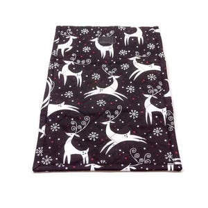 May include: Black quilted fabric with a white reindeer and snowflake pattern. The reindeer have large antlers and are in various poses. Red dots are interspersed among the snowflakes. The edges are finished with a white border.