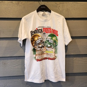Puede incluir: Camiseta blanca con un gráfico del Tostitos Fiesta Bowl del 1 de enero de 2002. El diseño incluye dos cascos de fútbol americano, uno dorado y otro verde, con las palabras "Fiesta Bowl" y "Oregon" impresas.