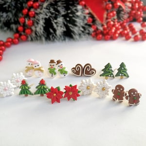 Pode incluir: Uma coleção de brincos com tema natalino, com desenhos de bonecos de neve, bonecos de gengibre, árvores de Natal, flocos de neve e estrelas de Natal. Os brincos são coloridos e festivos, perfeitos para a época festiva.