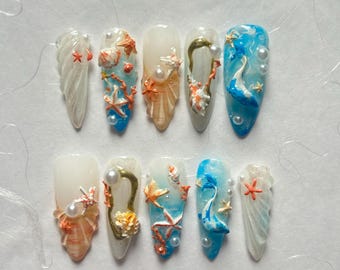Puede incluir: Diez uñas postizas largas, blancas y en forma de almendra con un tema de playa de verano. Cada uña está decorada con conchas marinas 3D, estrellas de mar, perlas y algas.