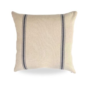 May include: A cream-colored pillow with two black stripes down the center.