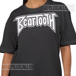 Puede incluir: Un letrero de madera rústica con el texto "Welcome to our home" en letras blancas. El letrero presenta un acabado envejecido y un diseño sencillo y acogedor, perfecto para la decoración de la puerta.